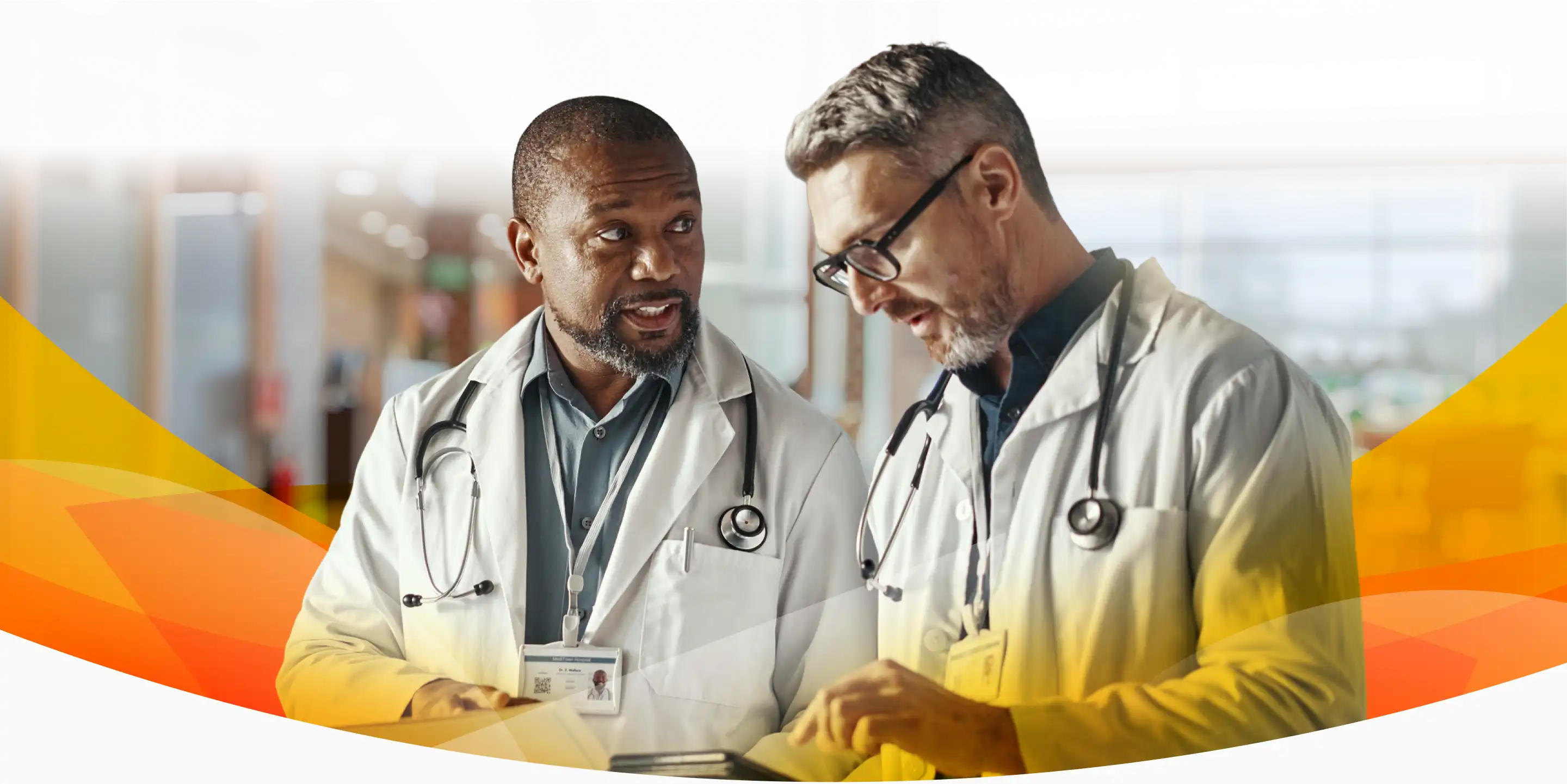 Two Vituity physicians collaborating in a hospital hallway