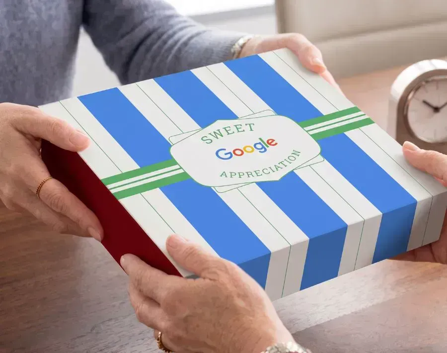 Two hands passing a custom branded Sugarwish gift box with company sleeve