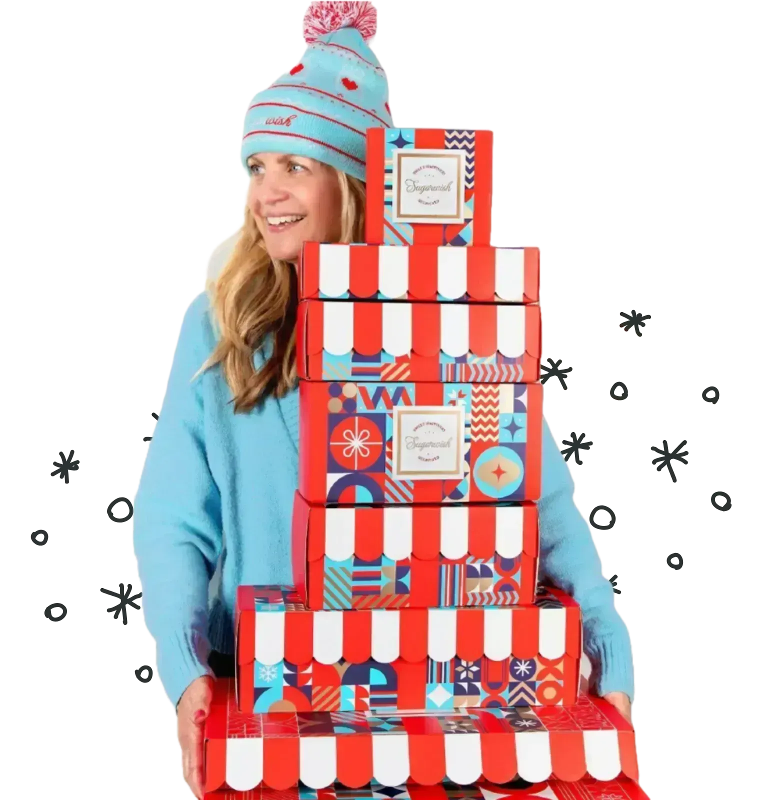 Woman balancing a tower of Sugarwish holiday gift boxes