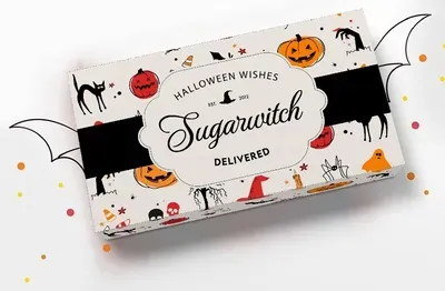Sugarwish Halloween gift box wrapped in the Halloween Wishes pattern sleeve, with bat wings and confetti