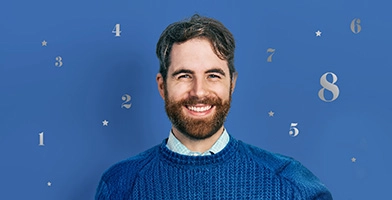 Smiling man with blue sweater and numbers one thru eight popping up around his face